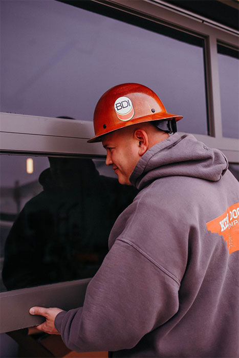 Employee working on garage door installing glass panels